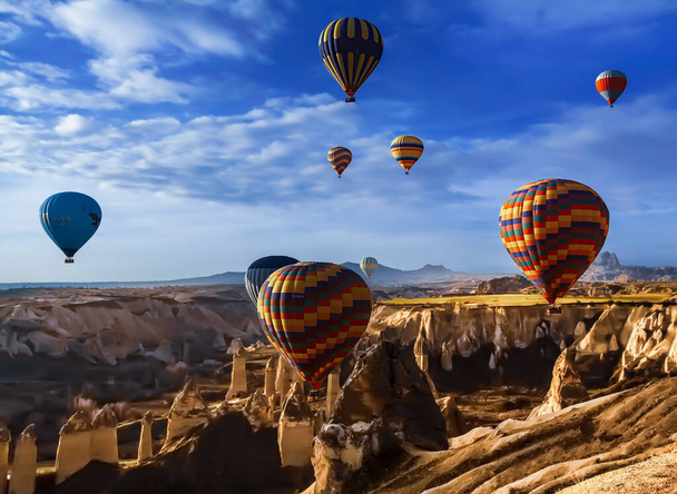Landscape of fabulous Kapadokya. Colorful flying air balloons in sky at sunrise in Anatolia. Vacations in beautiful destination in Goreme, Turkey - Photo, Image