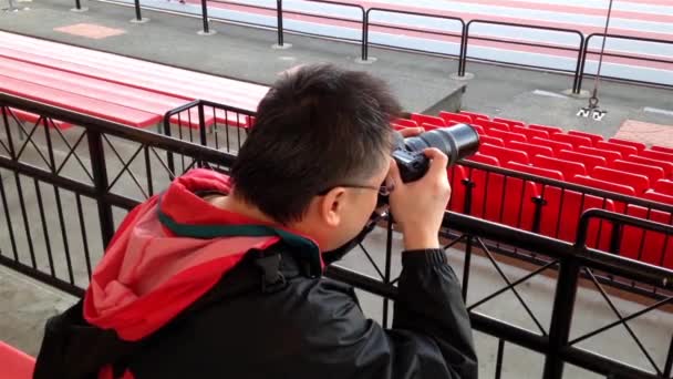 Photographer taking pictures with DSLR camera at sport field - Footage, Video