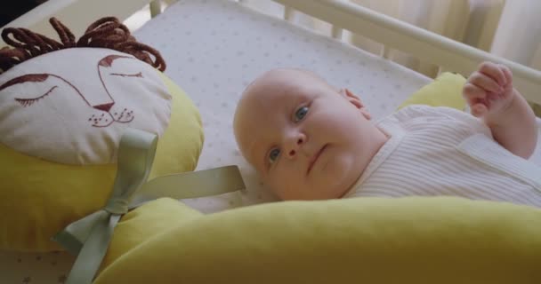 自由な健康な赤ちゃん時代. かわいい小さな新生児の微笑む赤ちゃんの肖像画。 ベッドシートに横たわる甘い美しい新生児のクローズアップ,演劇はつま先笑顔を見るカメラに触れる. - 映像、動画