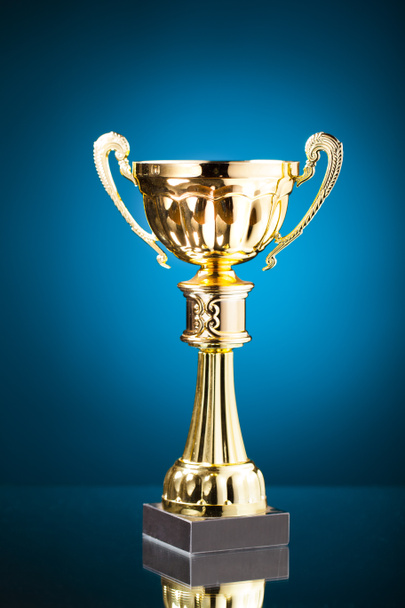 trofeo copa de oro sobre fondo azul
 - Foto, Imagen