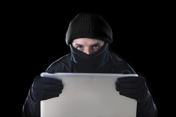 hacker férfi fekete használ laptop számítógép hackelés a jelszót és a személyes adatok bűncselekmények - Fotó, kép