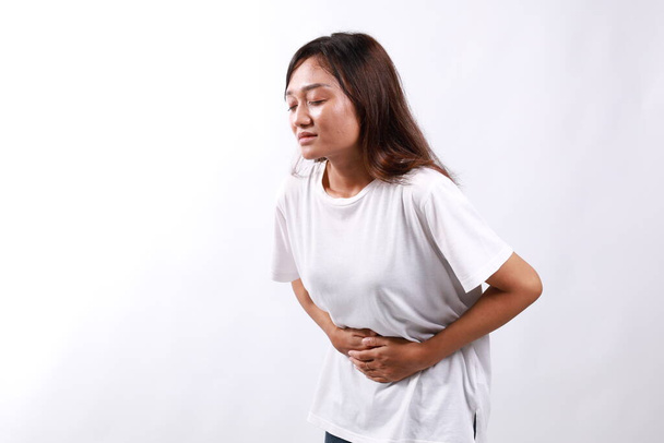Jeune asiatique femme a mal à l'estomac isolé sur fond blanc avec copyspace - Photo, image