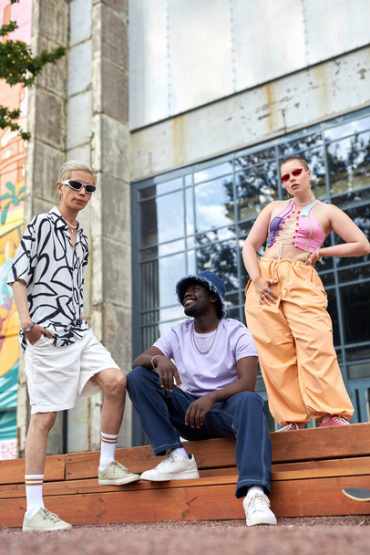 Muoti muotokuva monipuolinen ryhmä nuoria yllään trendikkäitä asuja poseeraa kaupunkiympäristössä - Valokuva, kuva