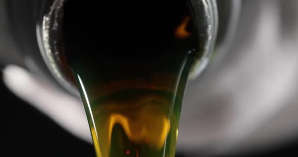 Wlewanie oleju silnikowego z czarnej butelki do silnika. Wymiana oleju w warsztacie samochodowym - Materiał filmowy, wideo