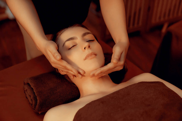Kavkazská žena si užívá relaxační antistresové masáže hlavy a hýčkání pleti kosmetické rekreace v teplých svíčkách osvětlení okolní salon lázně v luxusním resortu nebo hotelu. Tichý - Fotografie, Obrázek
