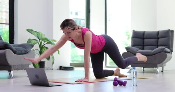 Fit atletický mladá žena dělá on-line cvičení na podložce doma. Aktivní zdravá dívka má rád sporty a dělá sportovní prkno - Záběry, video