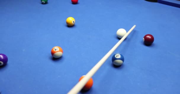 Gracz bilard przesuwa białą piłkę na stole z kijem bilardowym. Bilard gry - Materiał filmowy, wideo