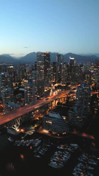 Splendida vista aerea sul centro di Vancouver di notte. Grattacieli e traffico sulle strade. British Columbia, Canada.  - Filmati, video
