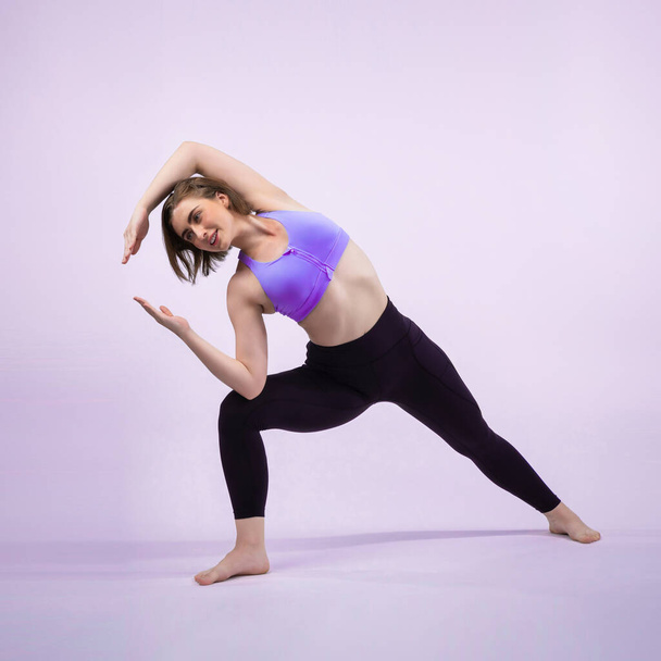 Volledige lichaamslengte vrolijkheid schot atletische en sportieve vrouw doet gezonde en meditatieve yoga oefening houding op geïsoleerde achtergrond. Gezonde actieve en lichaamsverzorging levensstijl - Foto, afbeelding
