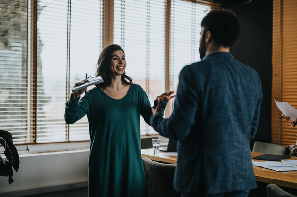 Eine Frau und ein Mann in einer dynamischen Diskussion während eines kreativen Teamtreffens in einem modernen Büroumfeld. - Foto, Bild