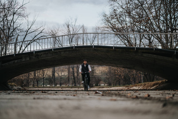 男性ティーンエイジャーは,自然の中でレジャータイムサイクリングをリリースし,橋の下で自由と喜びを描きます. - 写真・画像