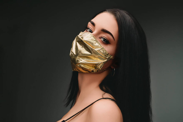 рост цен на маски для лица и дефицит в COVID-19 раз концепции, как красивая молодая женщина в маске для лица из золота, потому что она может себе это позволить, даже если они становятся чрезвычайно редкий хороший - Фото, изображение