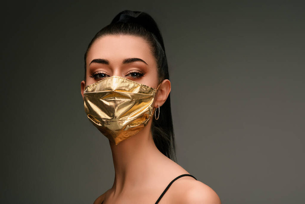 Yüz maskelerinin fiyatı artar ve COVID-19 kat konsept olarak güzel bir genç kadın olarak altın bir maske takar çünkü son derece iyi olsalar bile buna gücü yeter. - Fotoğraf, Görsel