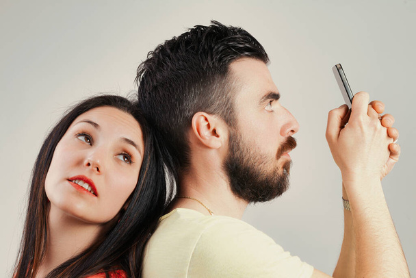 Жінка прагне до розмови; чоловік зайнятий своїм телефоном, розрив зв'язку розпливчастий між ними - Фото, зображення