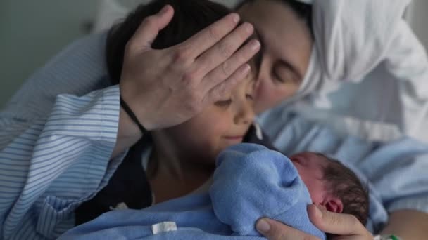 Семья приветствует новорожденного в больнице - брат держит ребенка, как мать смотрит на, празднуя первый брат сближения - Кадры, видео