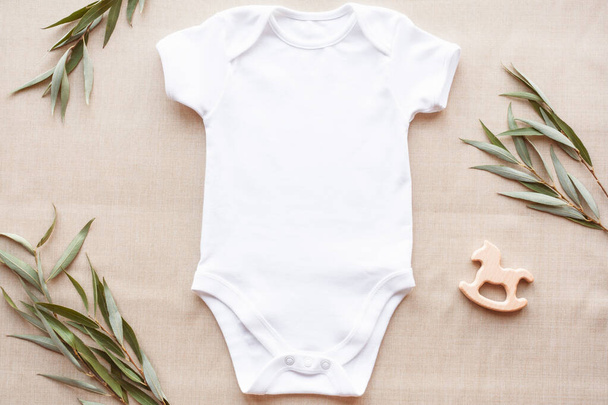 Mockup de macacão de bebê branco em linho com vegetação e brinquedo. Modelo de roupas de bebê em branco no estilo da fazenda, flat lay. - Foto, Imagem