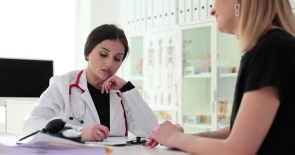 Consulta entre médico y paciente en clínica. Paciente femenina se comunica con ginecólogo - Metraje, vídeo