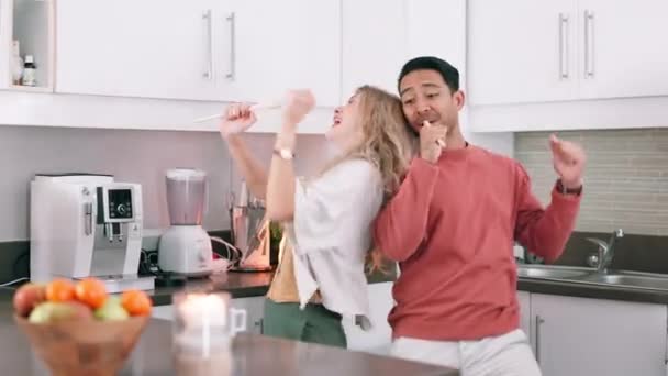 Happy couple, singing and dancing in kitchen with love, candle and romantic for date on weekend. Interracial marriage, care and fun for dinner on holiday and bonding together for anniversary in house. - Footage, Video