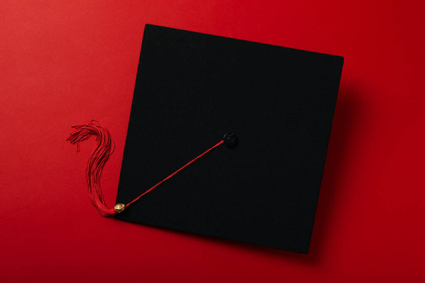 Végzős kalap diploma piros háttér. - Fotó, kép