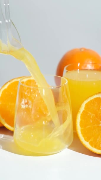 Pomerančová šťáva tekoucí ze džbánu do skla, zpomalený pohyb - Záběry, video
