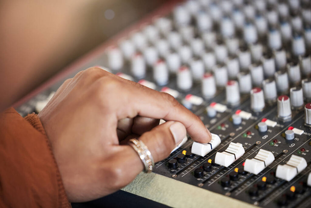 Hand, music producer and audio mixer in studio for volume level, frequency content and dynamic. Sound engineer, equipment and digital workstation for track record, consistency and creativity. - Photo, Image