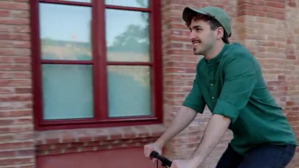 Junger glücklicher Mann mit Fahrrad in der Stadt. Millennial Hipster Kerl genießt Radfahren auf der Straße. Lebensstilkonzept über Verkehr und Menschen. - Filmmaterial, Video