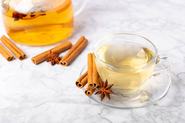 Fragrant hot tea with cinnamon stick and anise on a textured wooden background. A cup of hot tea with honey, lemon, mint and apples. Spicy tea with spices. Immunity tea. Health concept.Copy space. - Photo, Image