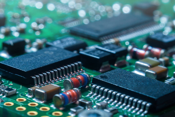 Primo piano del circuito stampato con processore, circuiti integrati e molti altri componenti elettrici passivi montati sulla superficie. - Foto, immagini