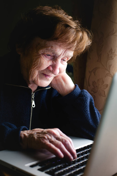 Seniorin tippt auf Laptop-Tastatur. - Foto, Bild