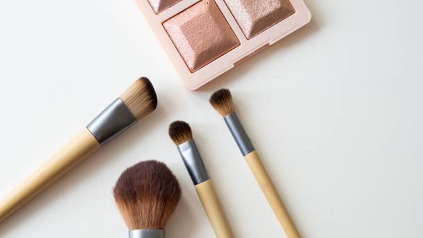 Wooden organic makeup brushes on white backdrop. Eco-friendly, sustainable beauty tools. - Photo, Image