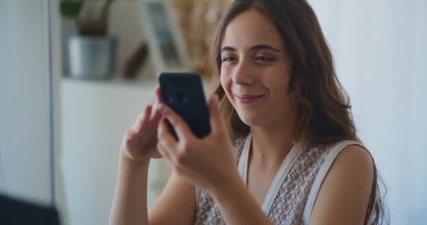 Женщина просматривает смартфон онлайн покупки дома - Кадры, видео