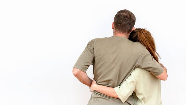 Rear view of caucasian heterosexual hugging couple isolated on white background. - Foto, afbeelding