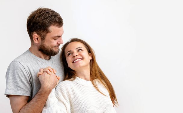 Happy loving young adult couple hugging on white background. Heterosexual couple in love. - Foto, immagini