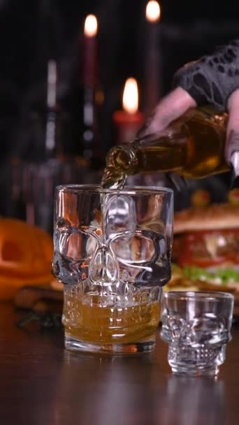 Cocktail Immersione profonda, una mano di streghe immerge un bicchierino di tequila in un bicchiere di birra. Aggiungi un po 'di eccitazione alla tua festa di Halloween. Tempo reale e lento. Video verticale - Filmati, video