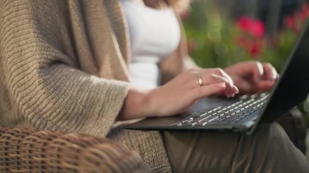 otthoni iroda, gyönyörű fiatal nő dolgozik a laptop, miközben ül egy székben, közelkép - Felvétel, videó