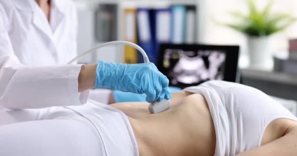 Diagnosi ecografica dello stomaco sulla cavità addominale della donna in primo piano clinica. Il medico passa sonda ad ultrasuoni sulla pancia del paziente e lavora sul pannello dello scanner. Diagnosi degli organi interni. - Filmati, video