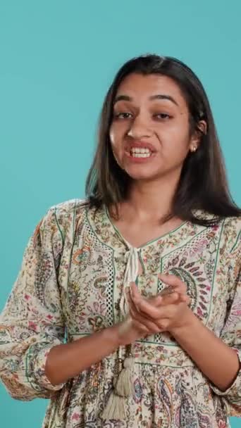 Video verticale Ritratto di donna indiana invidiosa che applaude ironicamente, mostrando frustrazione, sfondo in studio. Persona insolente risentita che rotola gli occhi e applaude per scherzo, sentirsi irritato, macchina fotografica A - Filmati, video
