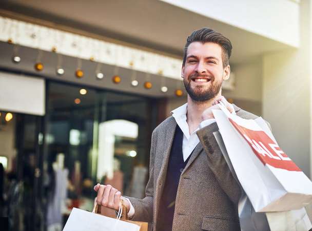 Man, portrait and shopping bags with sale in city for retail promotion, store discount and happy. Shopper, person and customer with package outdoor for clothing, gift and fashion deal in urban town. - Photo, Image