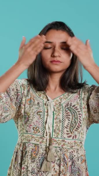 Vertical video Woman covering eyes, ears and mouth, imitating three wise monkeys. Indian person doing don t see, don t hear and don t speak hand gesturing concept, studio background, camera A - Footage, Video