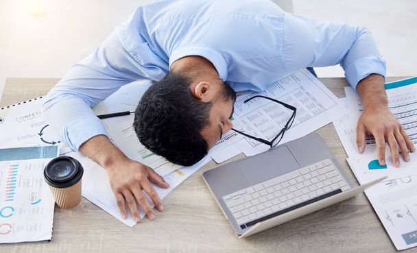 Üzletember, fáradt és az irodában alszik, kiégési kockázattal, túlhajszolt vagy szunyókál az alacsony energiáért. munkahely, kimerült vagy fáradt alvó férfi könyvelő, pénzügyi dokumentumok vagy laptop az asztalon. - Fotó, kép