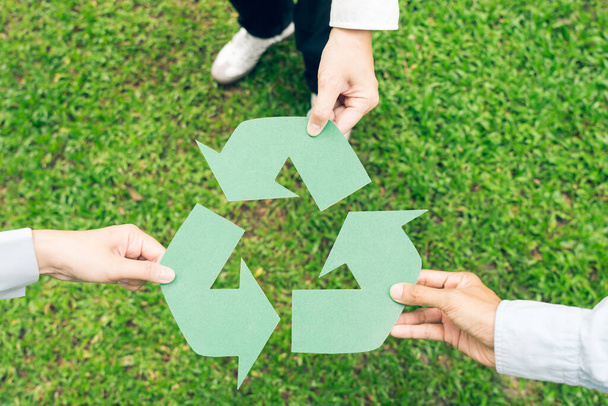 Lidé držící recyklační symbol na zeleném jarním pozadí. Koncept svátků Země. - Fotografie, Obrázek