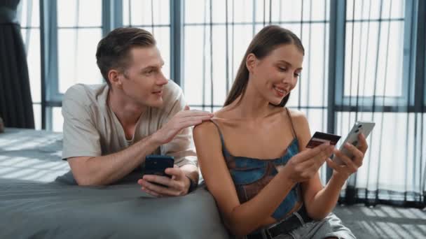 Genç çift, online ödeme uygulaması ve dijital cüzdanı kullanarak kredi kartıyla ödeme yaptıktan sonra mutlu ve heyecanlı hissediyorlar. Mobil internet üzerinden alışveriş ve modern alımlar. Düzenle - Video, Çekim