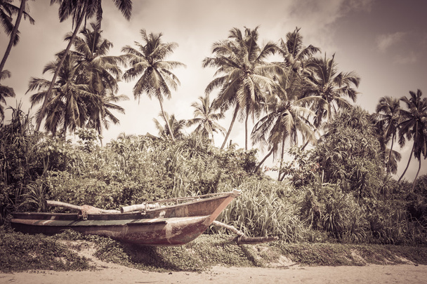 Barco de pesca en una playa tropical con palmeras en el backgrou
 - Foto, imagen