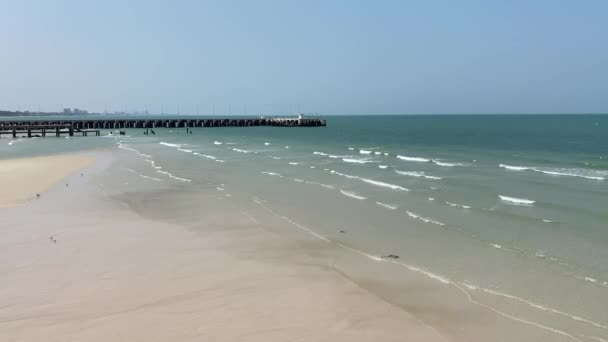 línea de playa cielo azul con olas y embarcadero no hay gente en el fondo. calma naturaleza vídeo resolución 4k en tiempo real. - Metraje, vídeo