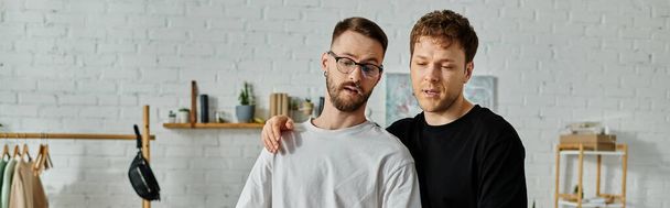 Zwei Männer, ein schwules Paar, arbeiten in einem Designeratelier zusammen, um trendige Kleidung zu entwerfen. - Foto, Bild