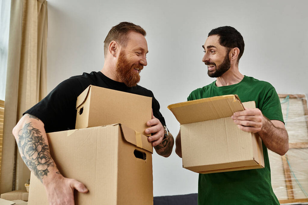 Una coppia gay tiene scatole nella loro nuova casa, simboleggiando un nuovo inizio pieno di amore e possibilità. - Foto, immagini