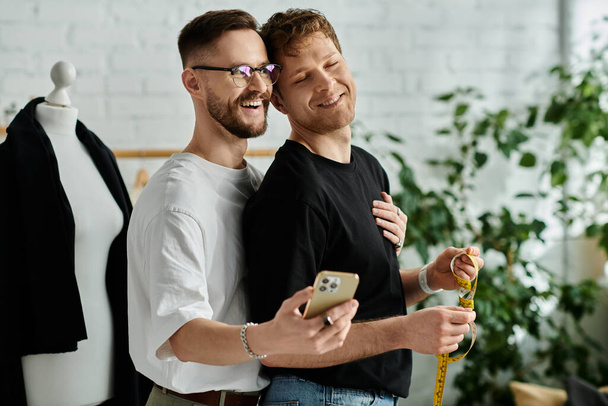Два чоловіки, гей-пара, стоять поруч, працюючи над модним вбранням у своїй дизайнерській майстерні. - Фото, зображення