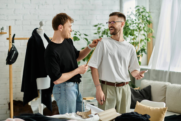 Two men in a designer workshop, working on stylish attire together. - Foto, afbeelding