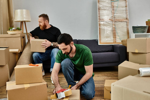 Two men, a loving gay couple, arranging boxes in a cozy living room while embarking on a new chapter in their life journey. - Photo, Image