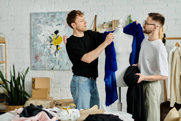 Двое мужчин, гей-пара, сотрудничают в дизайнерской мастерской по созданию трикотажных нарядов. - Фото, изображение